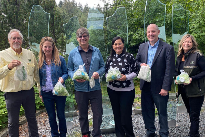 Group photo holding bag of plants